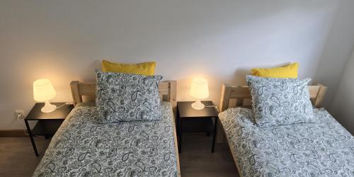a bedroom with two beds with pillows and two lamps at Apartament Wenecja z ogródkiem,parking in Ostrów Wielkopolski