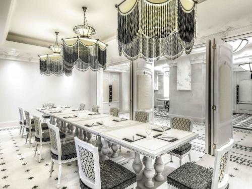 a dining room with a long table and chairs at Hotel de la Coupole - MGallery in Sa Pa