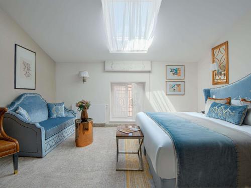 a bedroom with a large bed and a couch at Bachleda Luxury Hotel Kraków - MGallery Collection in Kraków