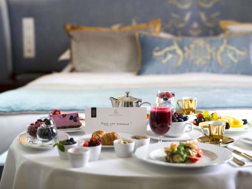 a table with a tray of food on a bed at Bachleda Luxury Hotel Kraków - MGallery Collection in Kraków
