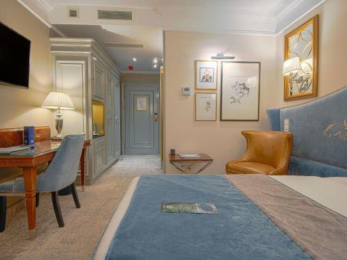 a hotel room with a bed and a desk at Bachleda Luxury Hotel Kraków - MGallery Collection in Kraków