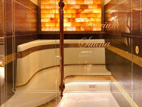 a bathroom with a glass shower with a tub at Bachleda Luxury Hotel Kraków - MGallery Collection in Kraków