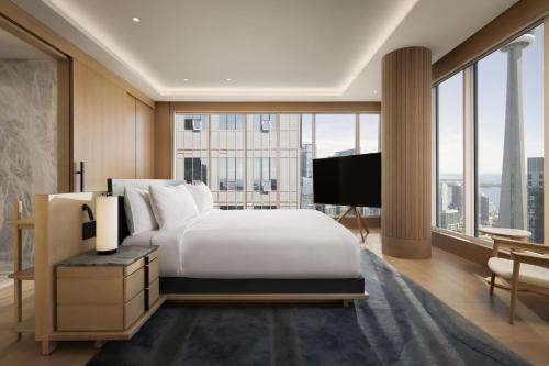 a bedroom with a large white bed and a large window at Nobu Hotel Toronto in Toronto