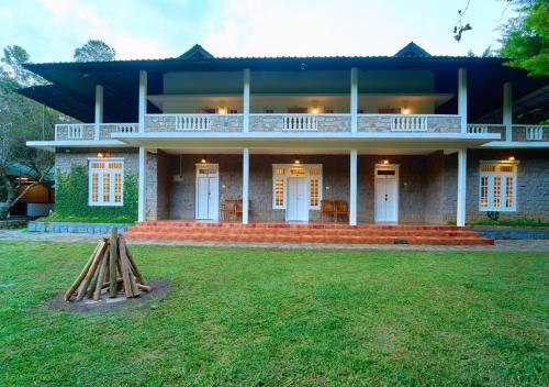 a large house with a lawn in front of it at Ministers Mansion Kanthalloor Pool Resort by VOYE HOMES in Kanthalloor