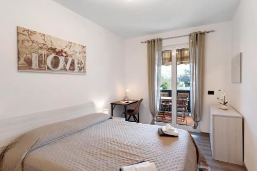 Un dormitorio blanco con una cama y un balcón. en Mareamore Apartment, en Lusignano