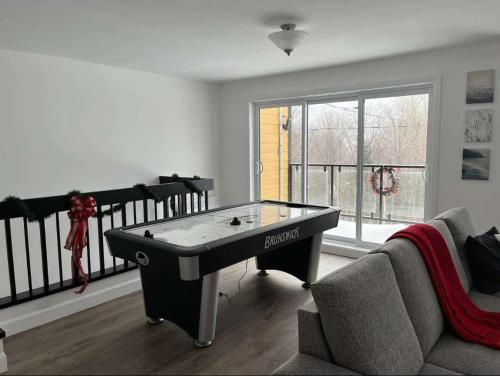 a living room with a ping pong table in it at Nature & Breathtaking View - Le Dumont - A in Saint-Philémon