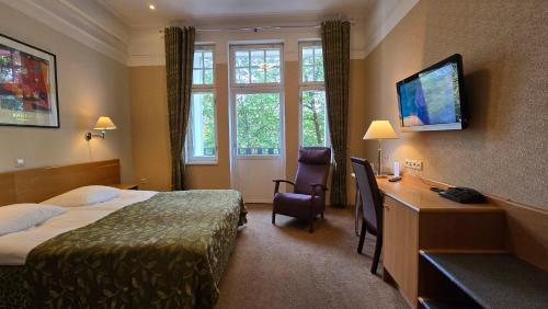 a hotel room with a bedroom with a bed and a desk at Barclay Hotel in Tartu