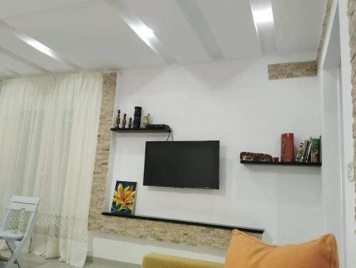 a living room with a television on a white wall at Dar ATTIA Ezzahra KELIBIA in Ḩammām al Ghazzāz