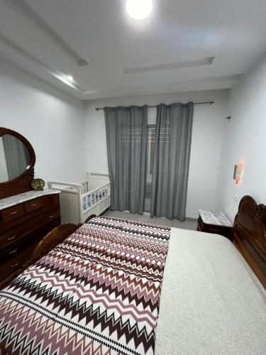 a bedroom with a large bed and a mirror at Dar ATTIA Ezzahra KELIBIA in Ḩammām al Ghazzāz