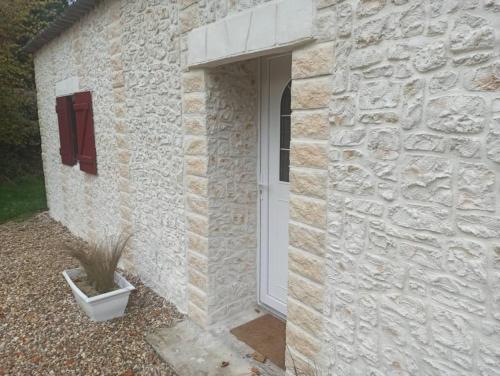 a stone building with a door and a plant at Nouveauté proche Pont-Audemer in Saint-Georges-du-Vièvre