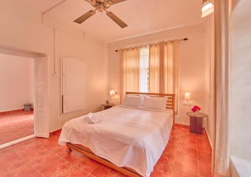a bedroom with a bed and a ceiling fan at Ministers Mansion Kanthalloor Pool Resort by VOYE HOMES in Kanthalloor