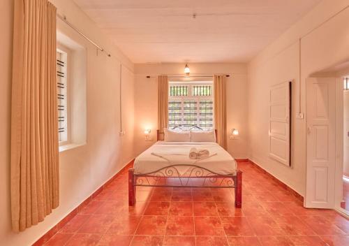 a bedroom with a bed and a window at Ministers Mansion Kanthalloor Pool Resort by VOYE HOMES in Kanthalloor