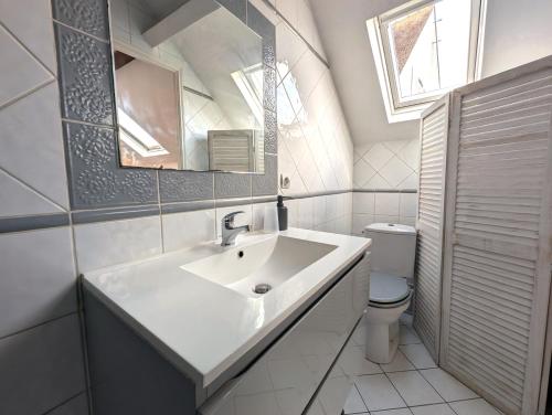 a white bathroom with a sink and a toilet at Maison & jardin proche Disney, Paris, Val d'Europe in Meaux