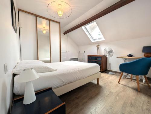 a bedroom with a white bed and a blue chair at Maison & jardin proche Disney, Paris, Val d'Europe in Meaux