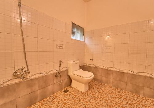 a bathroom with a toilet and a bath tub at Ministers Mansion Kanthalloor Pool Resort by VOYE HOMES in Kanthalloor