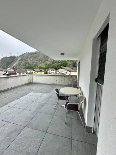 a patio with a table and chairs on a balcony at Haus Römerhof Apt 3 in Brig