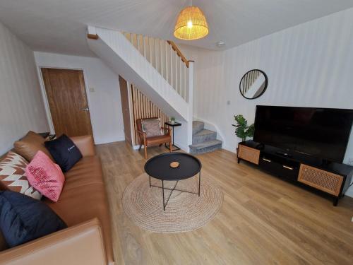 a living room with a couch and a television at Chic 2 Bedroom Close to Town with Free Parking in Tredegar
