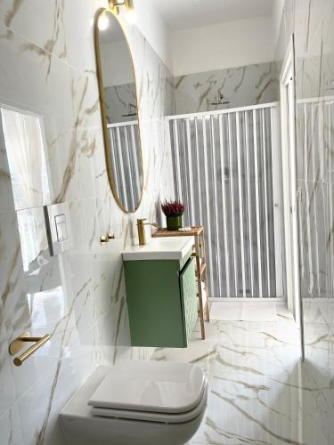 a bathroom with a sink and a toilet and a mirror at Dimora San Mario in Portici