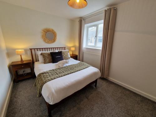 a bedroom with a bed with a teddy bear on it at Chic 2 Bedroom Close to Town with Free Parking in Tredegar