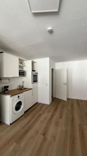 a kitchen with a washing machine in a room at Zentrales und renoviertes Apartment nähe Medienhafen mit Balkon in Düsseldorf