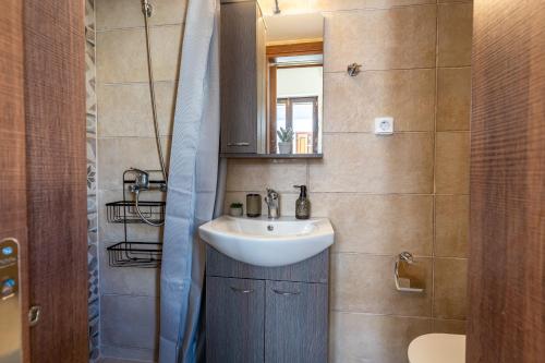 Un baño pequeño con lavabo y espejo. en The Storybook Maisonette, en Rethymno