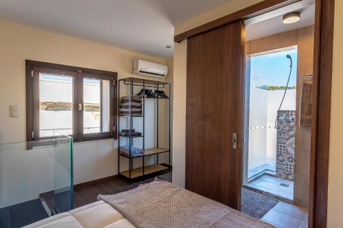 Un dormitorio con una cama y una puerta de cristal. en The Storybook Maisonette, en Rethymno