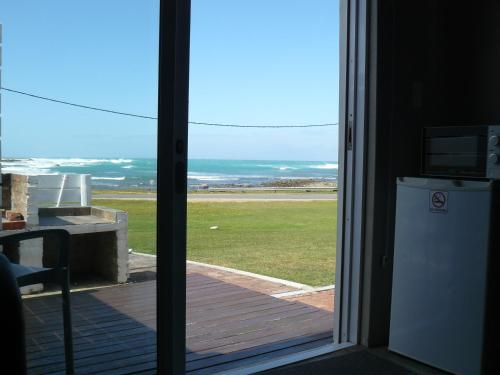 a sliding glass door with a view of the ocean at House of 2 Oceans in Agulhas