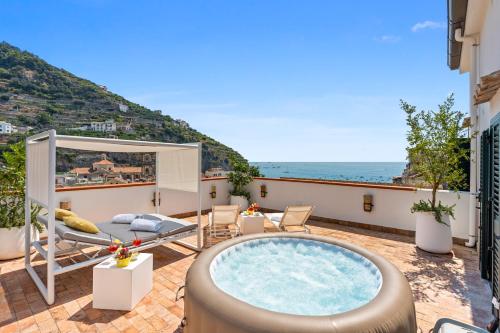a hot tub on a balcony with a view of the ocean at Torre Paradiso in Minori