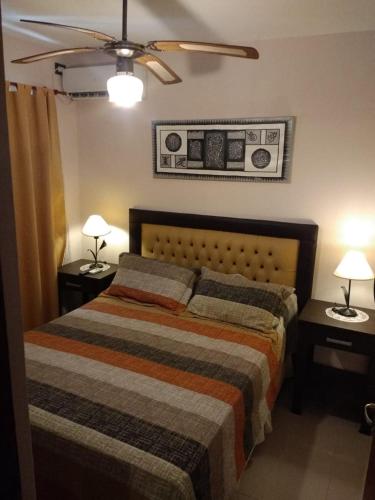 a bedroom with a bed with two night stands and two lamps at Departamento Céntrico Miralejos 3 in Villa Carlos Paz