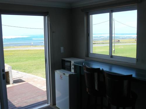 a room with a counter with chairs and a window at House of 2 Oceans in Agulhas