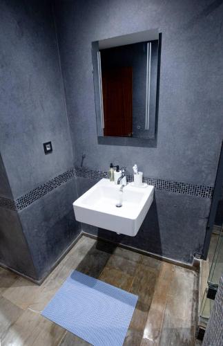 a bathroom with a white sink and a mirror at Gueliz Gem Chic, Comfy & Central in Marrakech