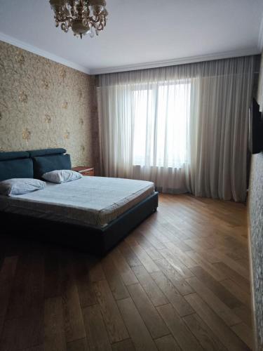 a bedroom with a bed and a large window at Fabolous Apartment In The City Center in Tbilisi City