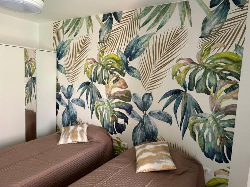 a bedroom with two beds with a tropical wallpaper at Casa Caletillas in Candelaria