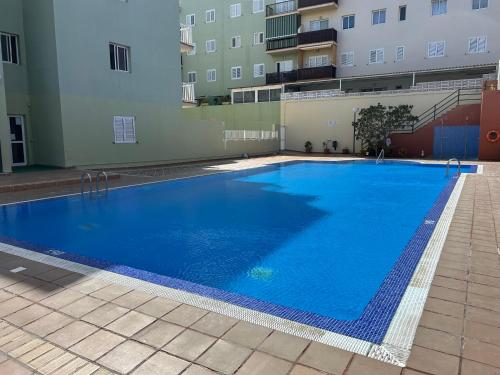 a large blue swimming pool next to a building at Casa Caletillas in Candelaria