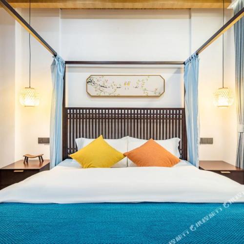 a bedroom with a large bed with colorful pillows at Floral Zhujiajiantuan Muting B&B in Zhoushan