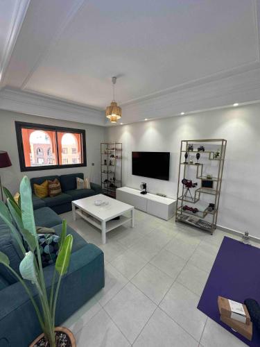 a living room with a couch and a tv at Jardin Majorelle Cozy Apartment in Marrakech