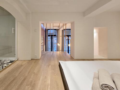 an empty living room with white walls and wood floors at Duplex Apartment in Mons Center 3 in Mons