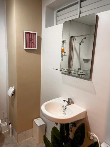 a bathroom with a sink and a mirror at Layover Stays 3 mins to Cebu Mactan Airport with Pool and Gym in Pusok