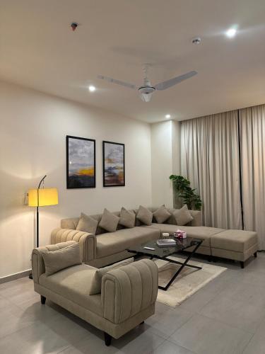 a living room with a couch and a table at Skypark ,luxury apartment ,with netflix and pool in Islamabad