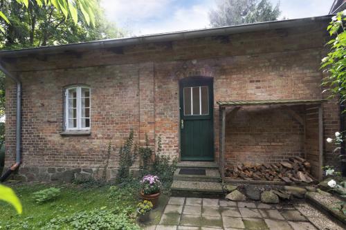 a brick house with a green door and stairs at Altes Polchower Pfarrhaus 