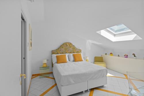 a white bedroom with a bed and a skylight at Torre Paradiso in Minori