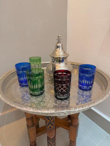 a glass table with four blue and green glasses on it at Majorelle Elegance City Center in Marrakech