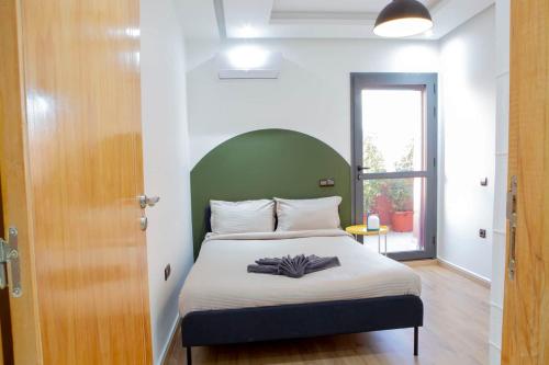 a bedroom with a bed with a green headboard at Majorelle Elegance City Center in Marrakech