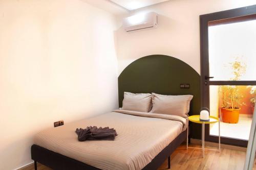 a bedroom with a bed with a green headboard at Majorelle Elegance City Center in Marrakech
