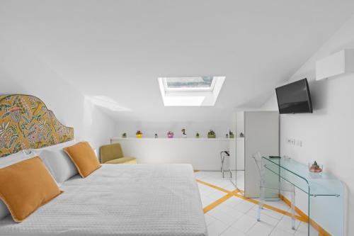 a white bedroom with a bed and a television at Torre Paradiso in Minori