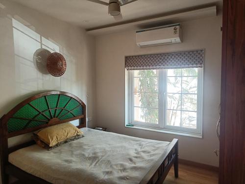 ChinchwadにあるSpacious 2BHK with ensuite bath and officeのベッドと窓のある寝室