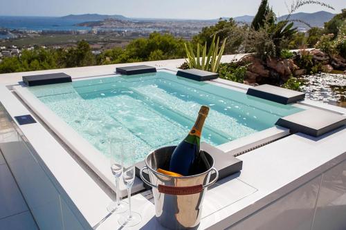 a bottle of wine in a bucket next to a swimming pool at Mirage Ibiza in Ibiza Town