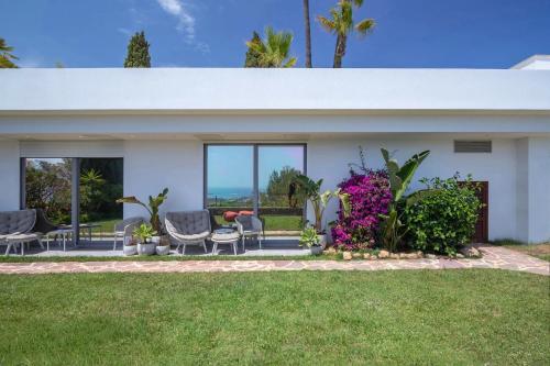 a white house with chairs and flowers in the yard at Mirage Ibiza in Ibiza Town