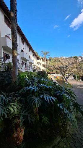 a building with a bunch of plants next to a street at Hotel Moinho de Pedra in Serra Negra