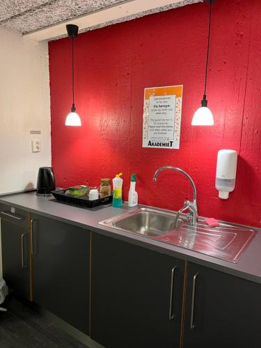 a kitchen with a sink and a red wall at Raulandsakademiet in Rauland